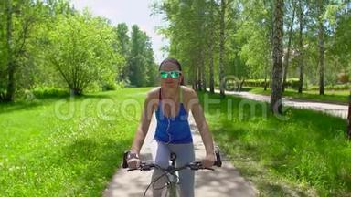 女人骑着一辆带智能手表心率监视器的自行车。 智能手表的概念。 快乐的年轻女子笑着笑着骑马